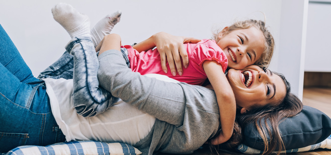 a mother and daughter laughing and hugging