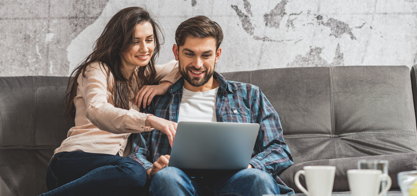 a couple using computer on the couch