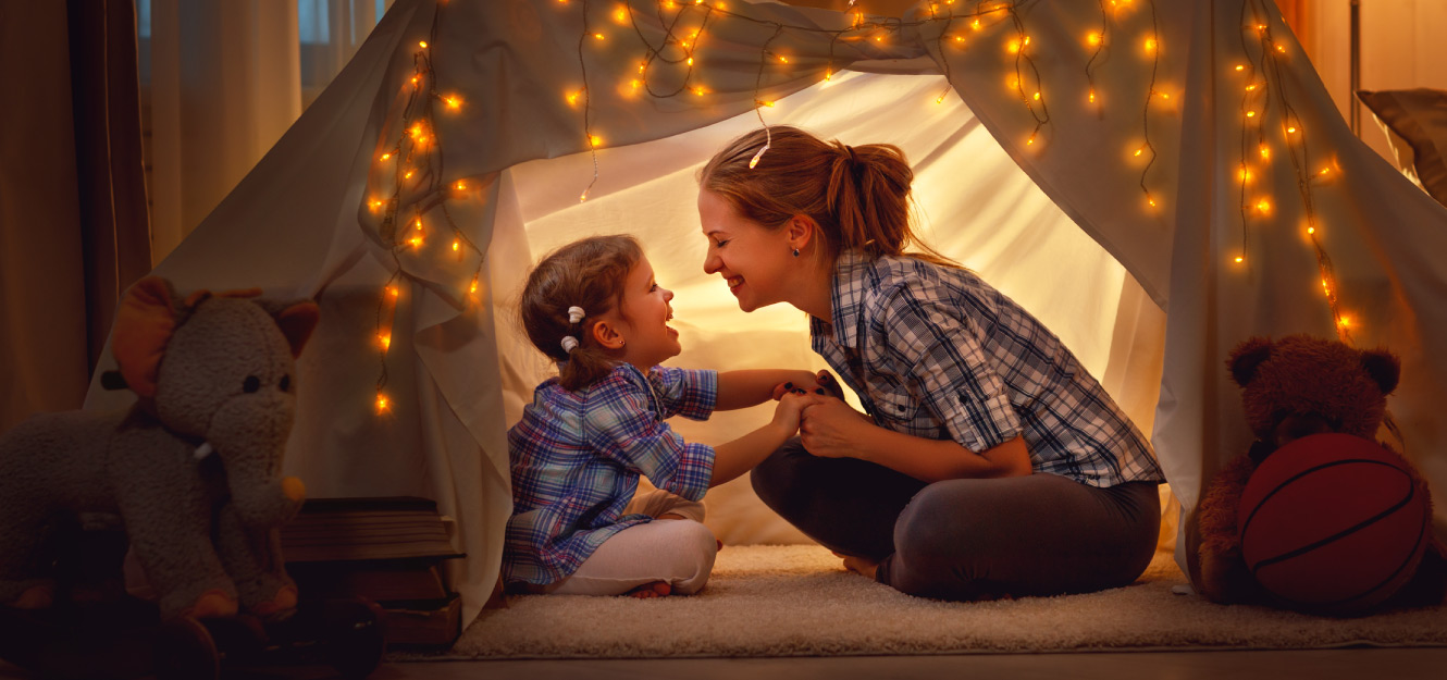 a mother and daughter playing in a tent
