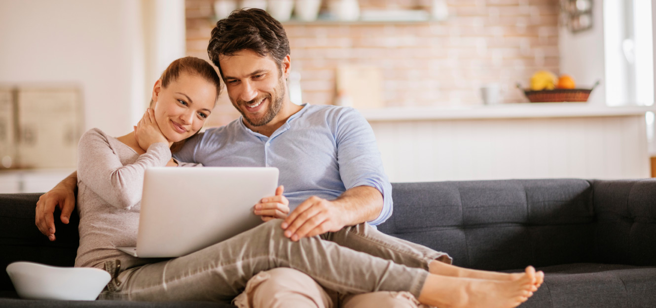 a couple using a computer on the couch